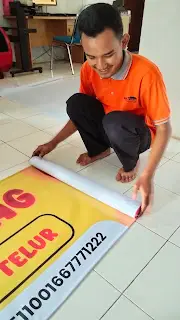 proses penggulungan banner